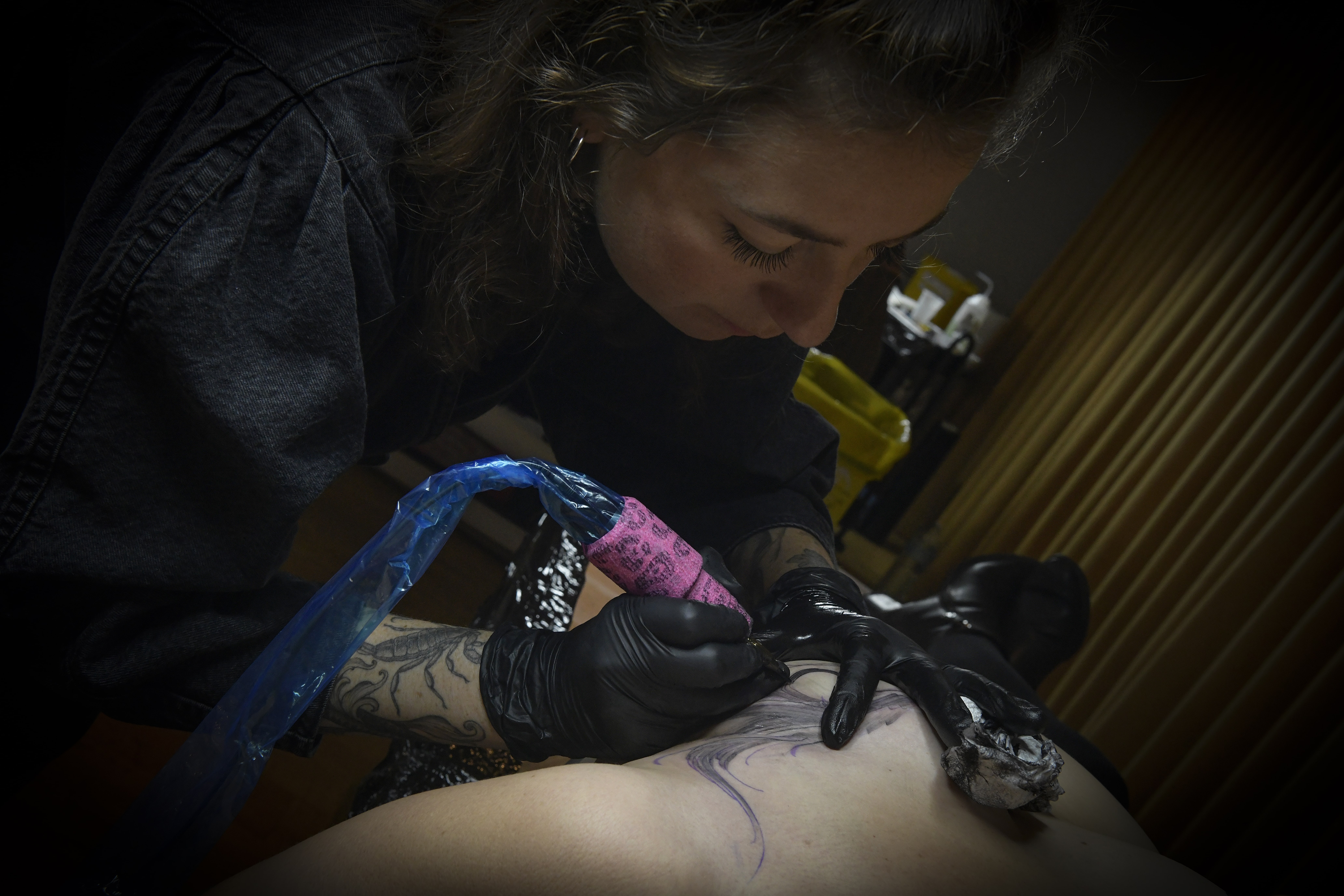 Cyd is tattooing Sophie during Rose Tattoo convention. . Credits: Nathalie kaïd - Photographe